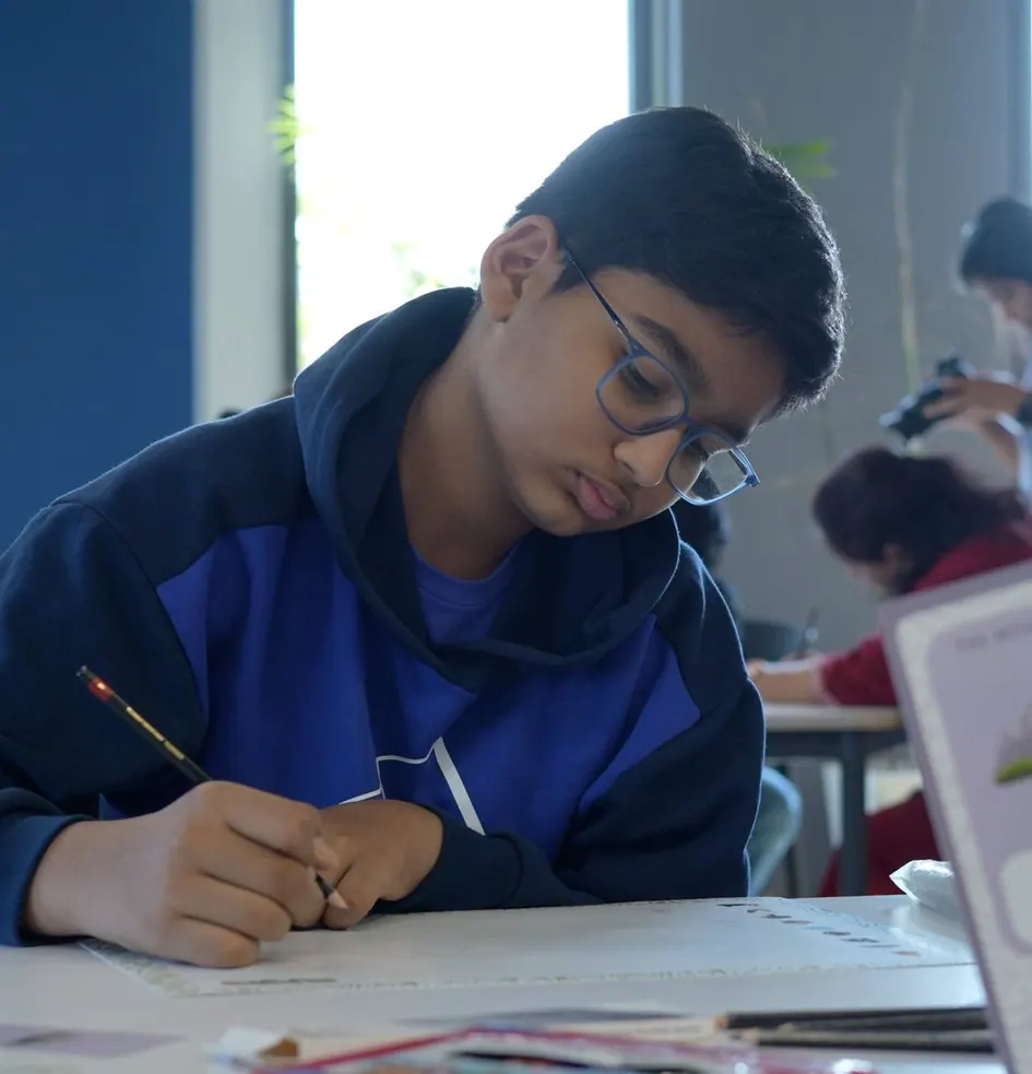 A student in glasses drawing his Territory Map, with a Mountain prompt card beside him
