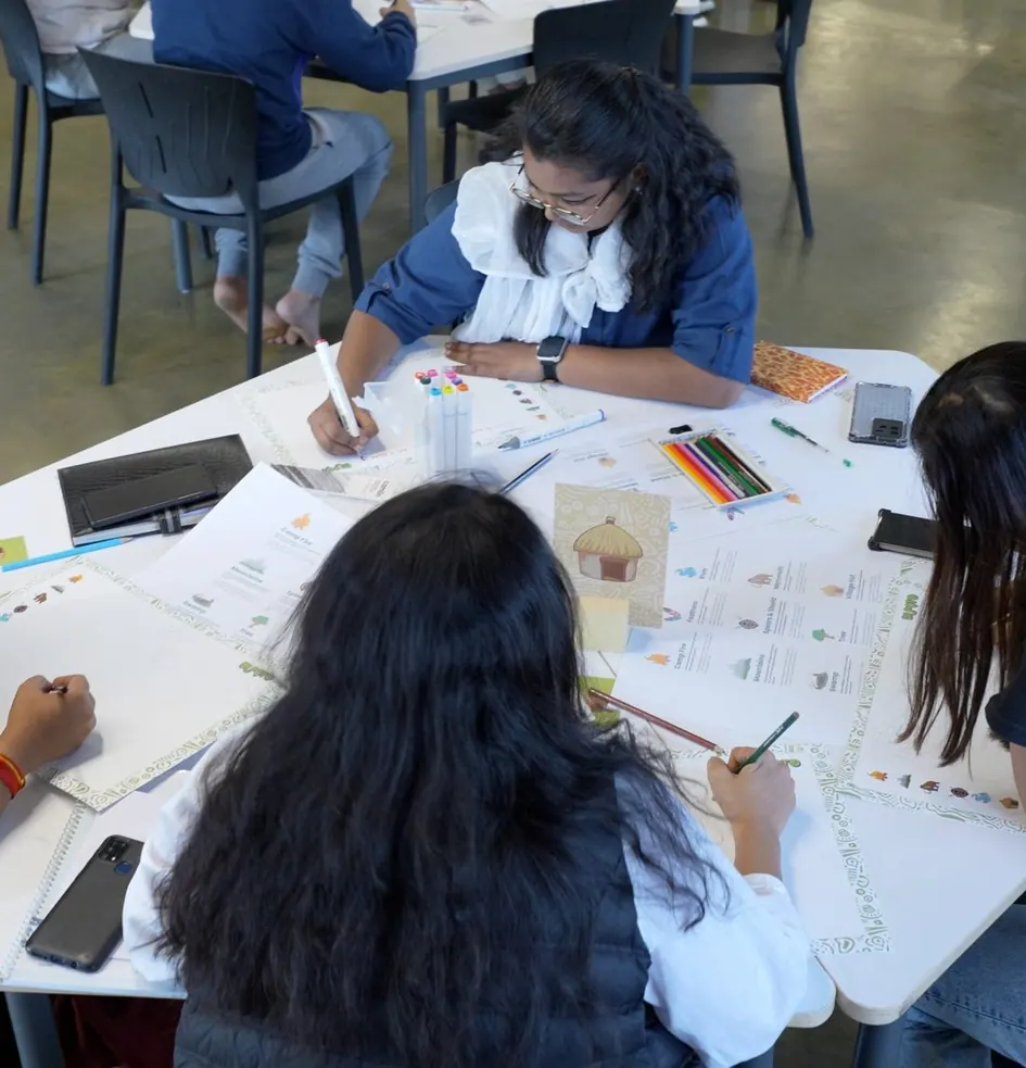 Four adults around a table, mapping together with coloured pens
