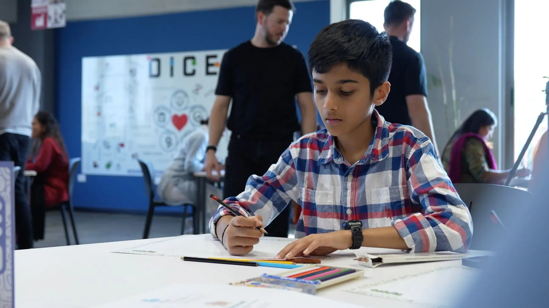 A student drawing his Territory Map at a Dupoto workshop while a facilitator looks on